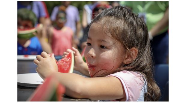 Small child enjoying watermelon in the watermelon eating contest