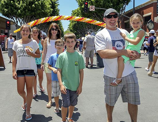 family smiling for a photo at a festival